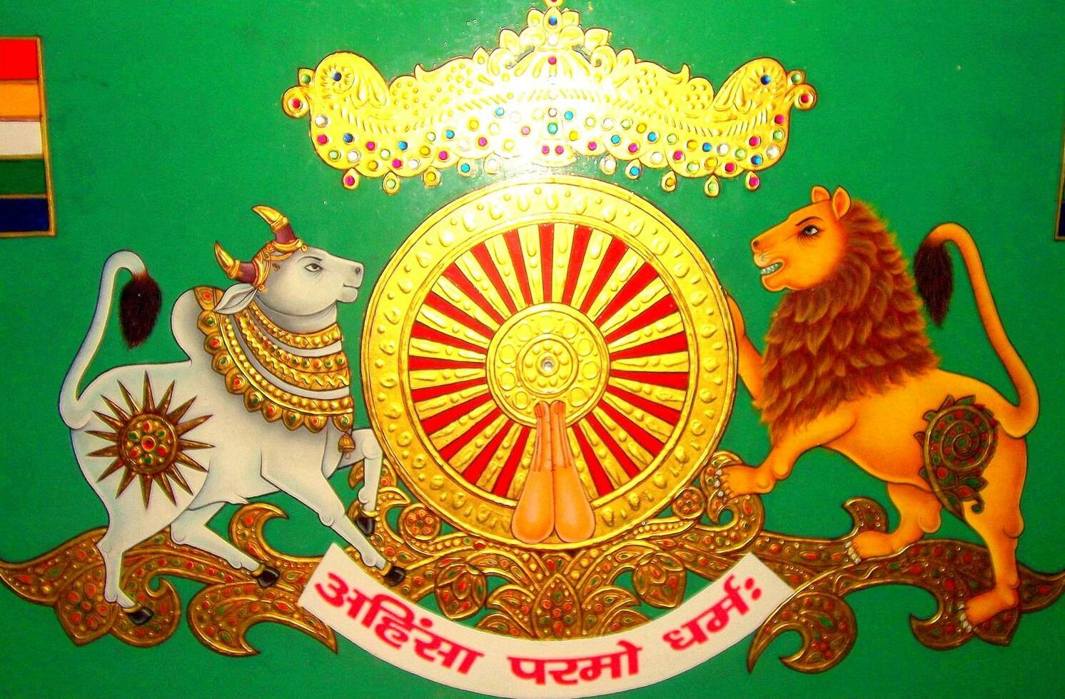 Ahimsa Paramo Dharma — sacred Jain emblem with bull, lion, and Dharma wheel on green background